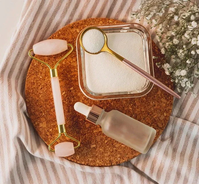 Flatlay mit Gesichtsroller, Serum und Naturkosmetik