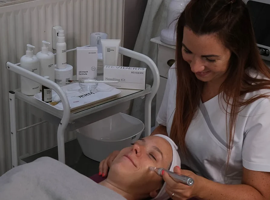 Kosmetikerin behandelt Kundin mit modernem Hautpflegegerät