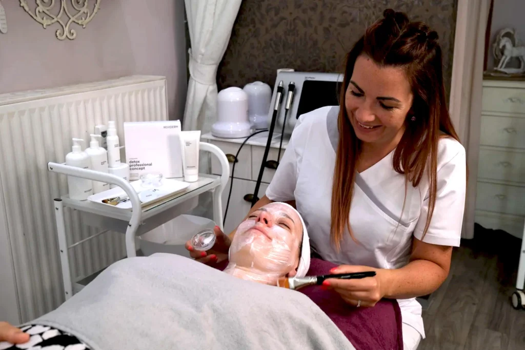 Kosmetikerin arbeitet konzentriert während einer Gesichtsbehandlung