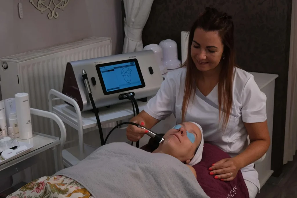 Kosmetikerin behandelt Kundin mit moderner Hauttechnologie