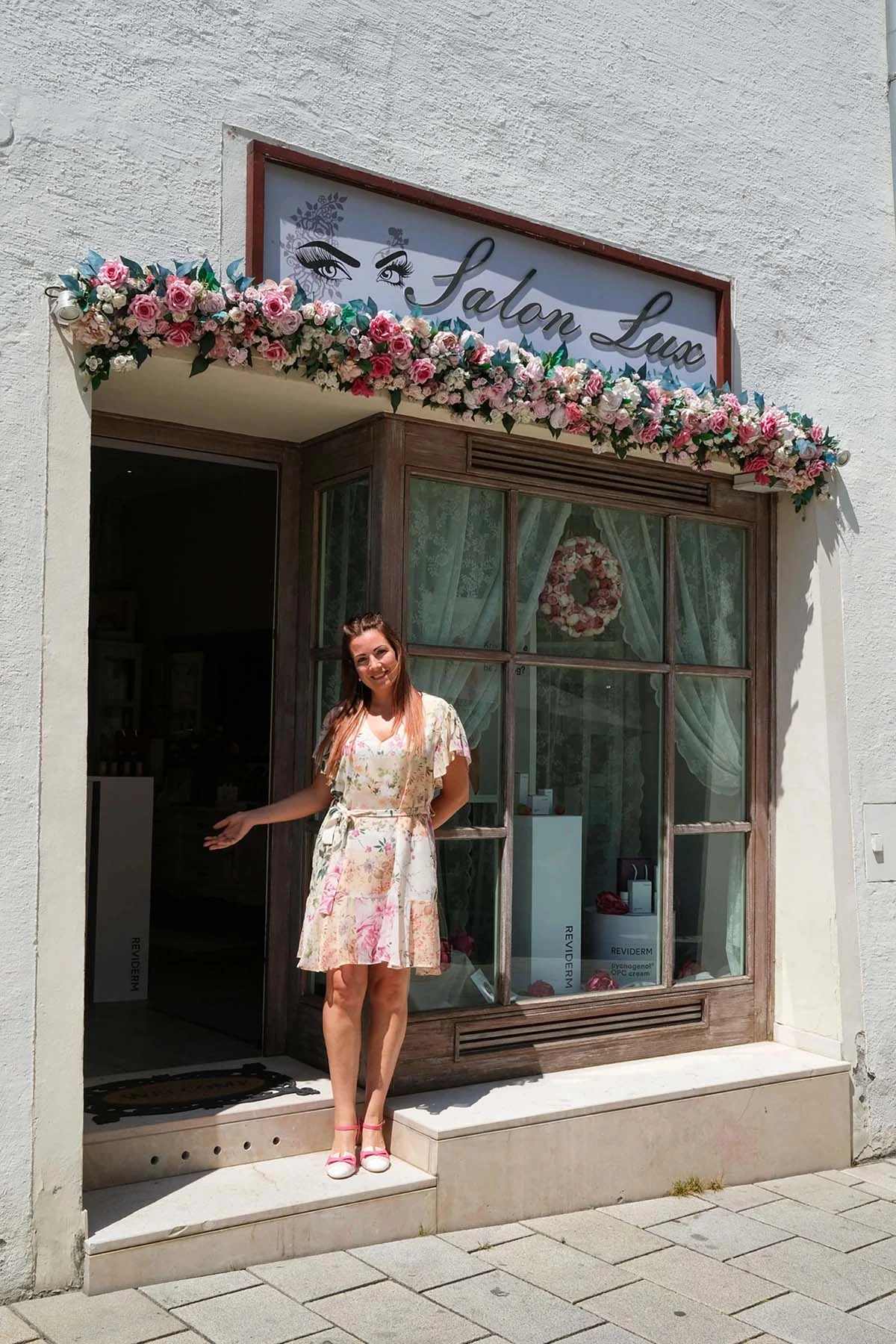 Außenansicht von Salon lux Hallein mit blumengeschmücktem Eingang